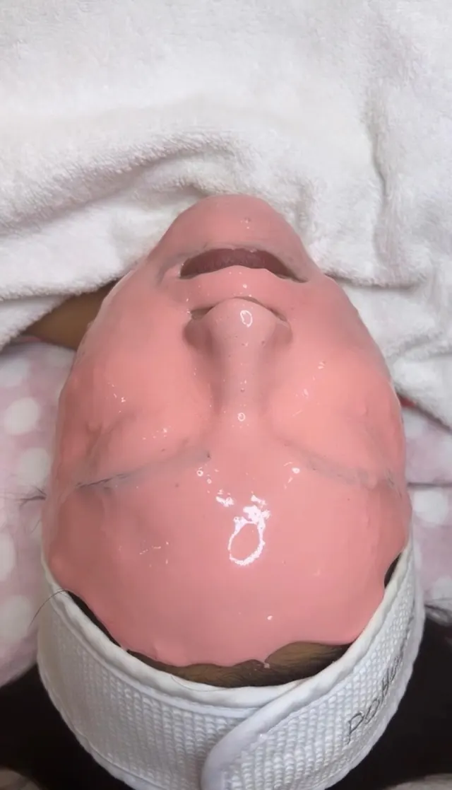 Mascarilla rosa en todo el rostro durante un facial en ELLE Beauty Spa