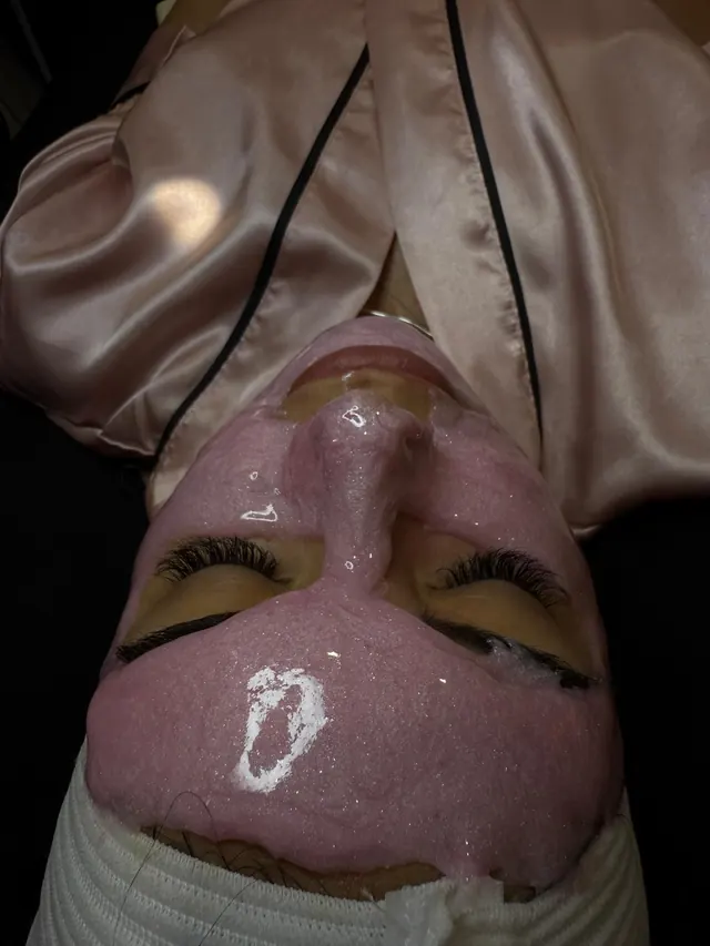 Mascarilla rosa con brillo durante un facial en ELLE Beauty Spa